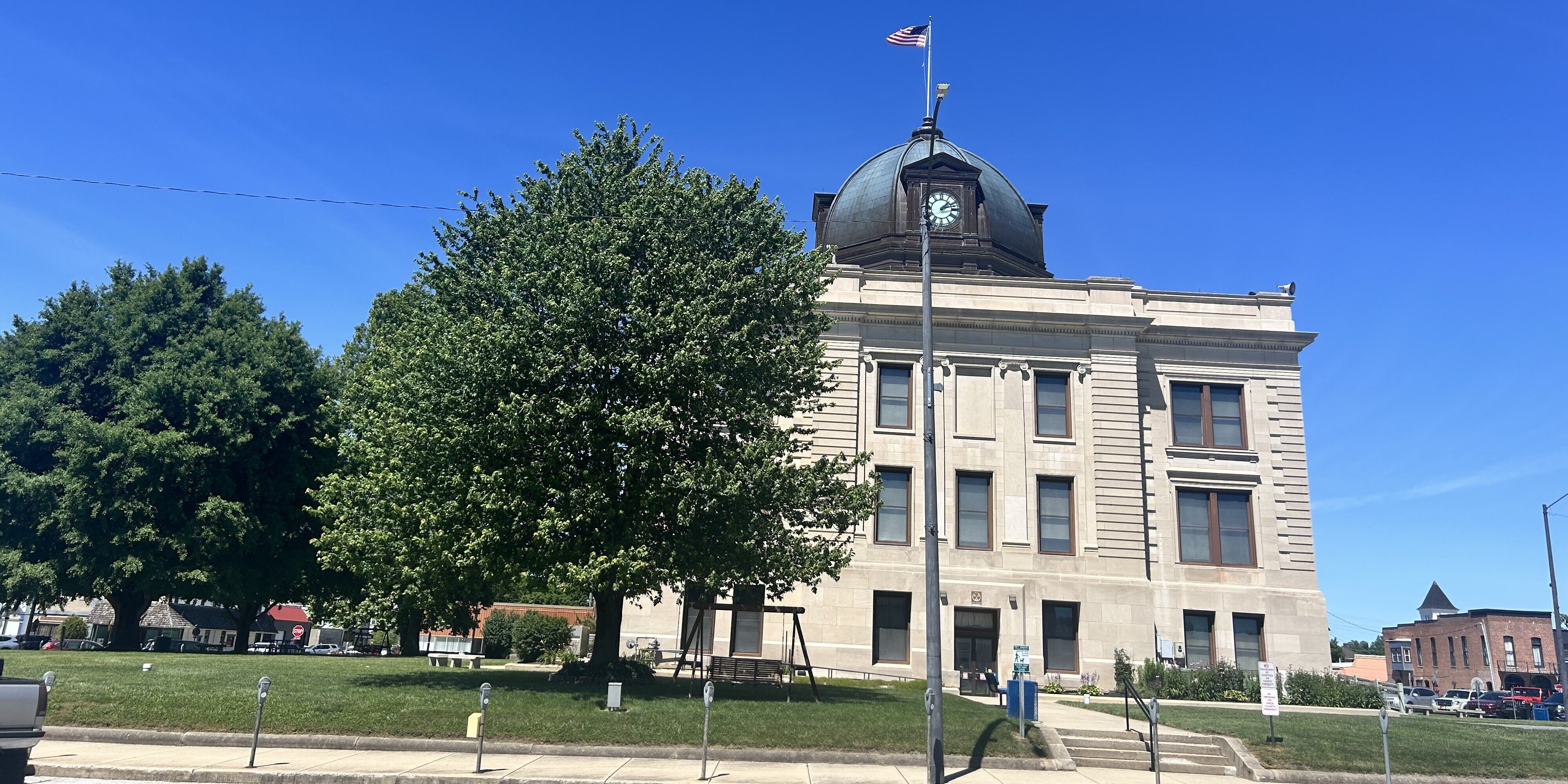 Owen County courthouse on a sunny day with a green tree out front